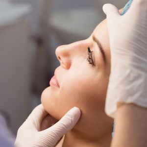 doctor-examining-womans-face-cosmetic-treatment