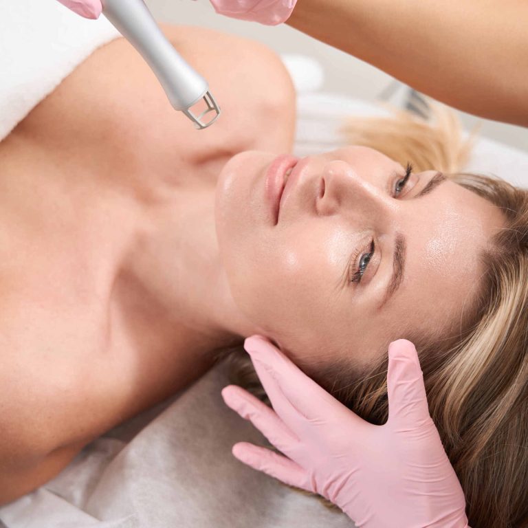 Top view of lady on laser skin resurfacing procedure Lady on laser skin resurfacing procedure, female cosmetologist in protective gloves uses CO2 laser